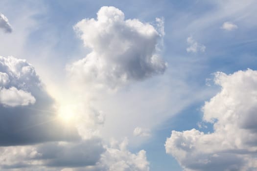 Morning sun light peeking out from a beautiful cloudscape sky. Dramatic nature background with natural lighting in the sky