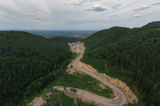 Aerial top vew of winding road in the mountains, drone shot. Altai Krai, Western Siberia, Russia. Road to Resort town Belokurikha 2