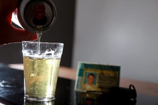 salvador, bahia / brazil - June 29, 2015: Beer bottle on bar table next to a driver's license and vehicle key, symbolizing drink consumption by vehicle drivers.