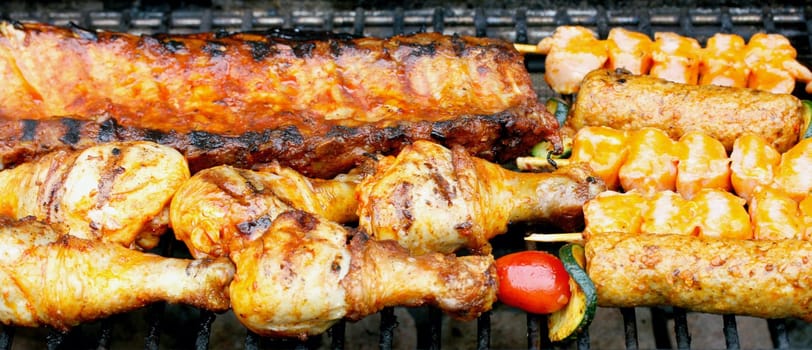 Various pieces of grilled meat on a grill grate