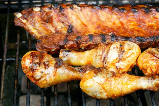 Various pieces of grilled meat on a grill grate
