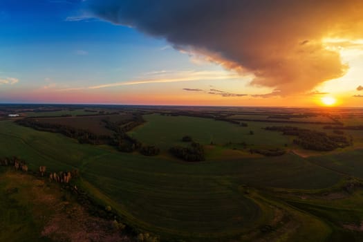 Aerial view on the field during sunset. Agricultural landscape from drone.