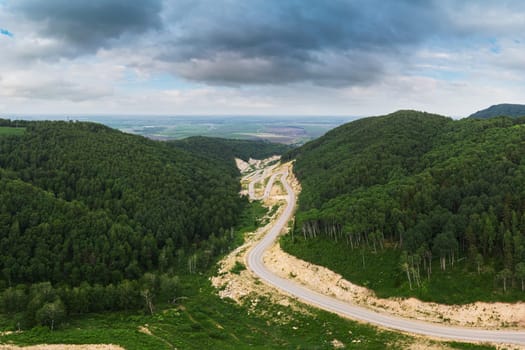 Aerial top vew of winding road in the mountains, drone shot. Altai Krai, Western Siberia, Russia. Road to Resort town Belokurikha 2
