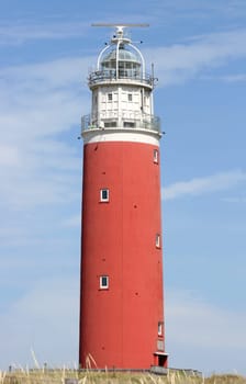 red lighthouse with blue sky in the background.