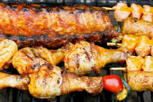 Various pieces of grilled meat on a grill grate