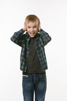 The boy covers his ears with his hands and shouts looking into the frame against a white background