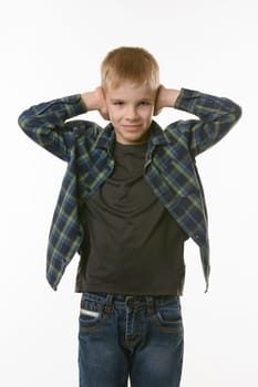 Boy covers his ears with his hands on a white background in everyday clothes