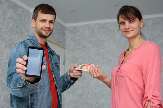 A self-employed man receives money from a girl for repairing a room and shows a phone with the mobile application