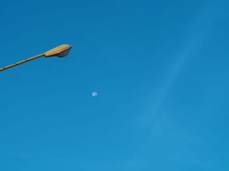 The street light tower on the background is blue sky And there is a small moon in the middle.Energy and nature concepts..Minimal image.