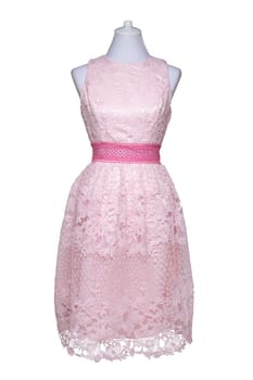 Lacy dress isolated. Closeup of a pink stylish sleeveless evening dress with lace on mannequin isolated on a white background. Summer fashion.