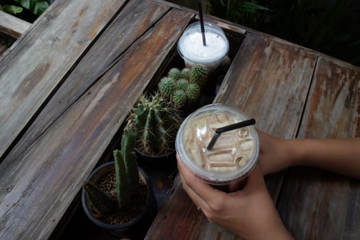 Hand on iced coffee drink, stock photo
