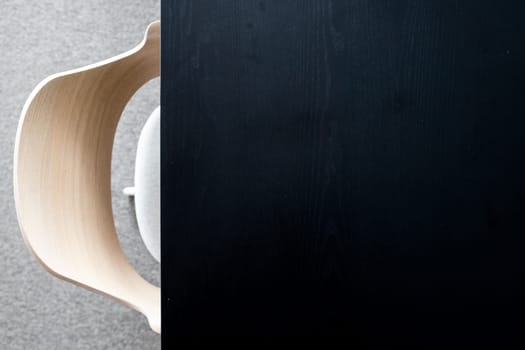 Designers armchair by black office desk. Modern minimalist workplace. Copy space.