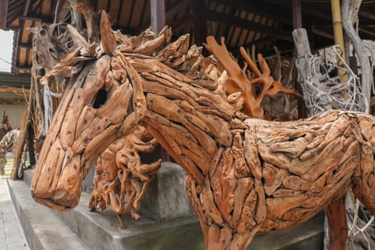 Wooden statue of a horse. Art and work of Balinese artists. Wooden art. Horse made of pieces of old wood. Big horse head art statue from wooden pieces. Ubud, Bali, Indonesia. March 2020.