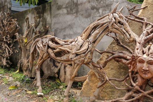 Wooden statue of a horse. Art and work of Balinese artists. Wooden art. Horse made of pieces of old wood. Ubud, Bali, Indonesia. March 2020.