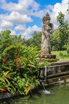 Dewi Sri or Shridevi the rice goddess. Stone figure of one of balinese godness. Water Palace of Tirta Gangga in East Bali, Indonesia. Stone statue from hindu myths.