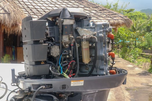 Used outboard boat engine 200 HP - 2 stroke. Heavy engine Yamaha two stroke. Powerful boat engine suspended at stern of boat. Engine metal parts and engine parts damaged by sea salt and corrosion.
