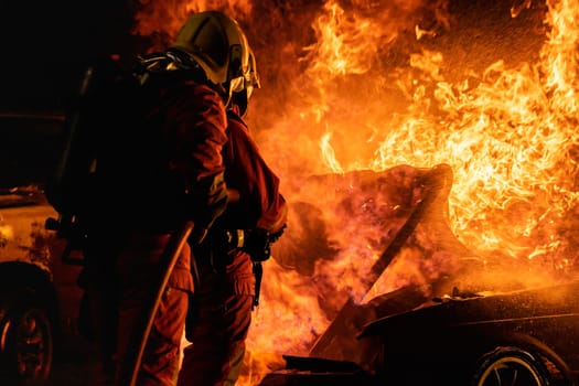 Firefighters use Twirl water fog fire extinguisher to fight with the fire flame from car accident of traffic collision in highway road. Firefighter safety disaster accident and public service concept.