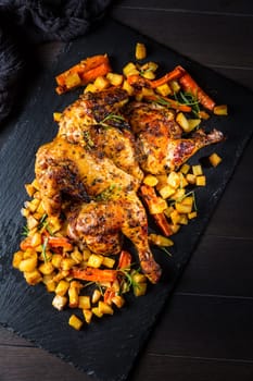 Butterflied grilled whole chicken with roasted vegetables and potatoes. Roadkill chicken style with herbs and lemon.