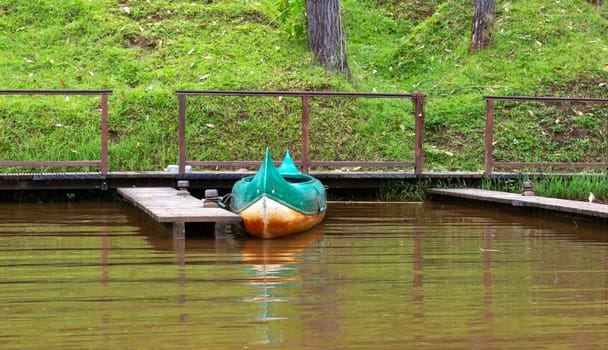 .One boat on a lake is parked on a jetty