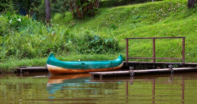 .One boat on a lake is parked on a jetty