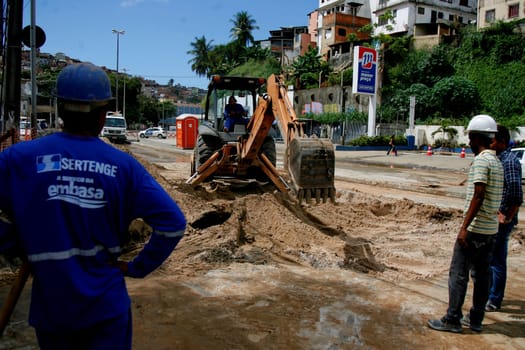 salvador, bahia / brazil - may 4, 2015: workers make repairs in a place where the pipeline broke, damaging damage on the street in the city of Salvador.