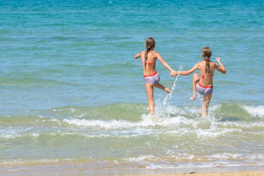Children fun and funny run swimming in the sea, left empty place for insertion