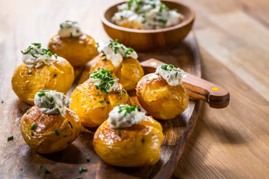 Small oven baked potatoes with sour cream with butter and chives