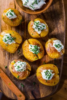 Small oven baked potatoes with sour cream with butter and chives