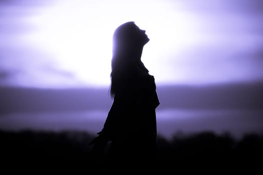 Silhouette in front of sunset or sunrise in summer nature. Symbol for healing burnout therapy, wellness relaxation or resurrection.