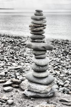 stones balancing on top of each to make a tower on a beach
