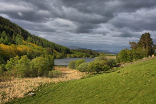 a lake in snowdonia under a grey cloudy sky
