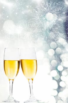 Glasses with champagne against fireworks and silvery background