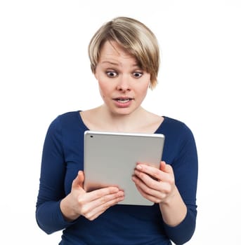 Young woman holding an electronic tablet and looking amazed, isolated on white