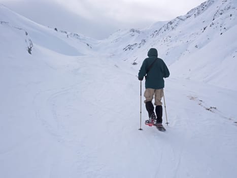 Winter landscape in the Alps with snowshoe hikers