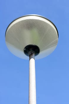 A street lamp, blue sky in the background.