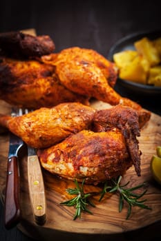 Spicy grilled chicken with lemon on wooden background