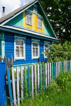 Traditional village house in Belarus. Windows with carved shutters and curtains. Vertical image