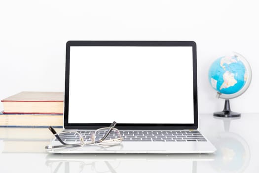 Laptop mockup with blank screen and Eye glasses on book and simulated world on table