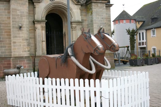 Two brown, wooden horse with black mane.