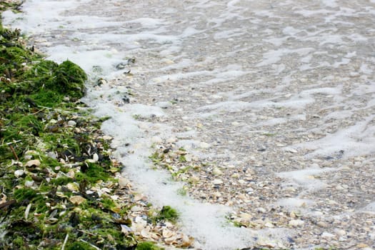 Waves with white crests inundate the sandy beach