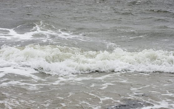 Waves with white crests inundate the sandy beach