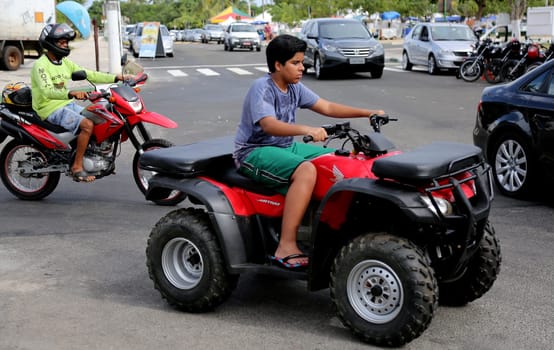 camacari, bahia / brazil - january 22, 2015: young man is seen without protective equipment, flying a quad in the Guarajuba district in the city of Camacari.