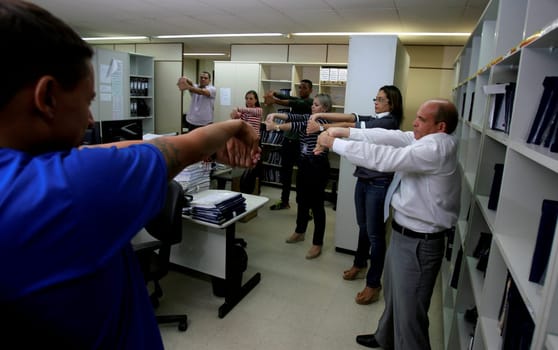 salvador, bahia / brazil - december 17, 2014: employees of the regional labor court in the city of Salvador are seen doing work gymnastics in the workplace.
