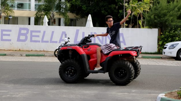 camacari, bahia / brazil - january 22, 2015: young man is seen without protective equipment, flying a quad in the Guarajuba district in the city of Camacari.