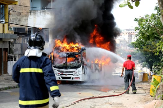salvador, bahia / brazil - january 23, 2015: a member of the fire brigade extinguishes a fire in a public transport bus in the city of Salvador.
