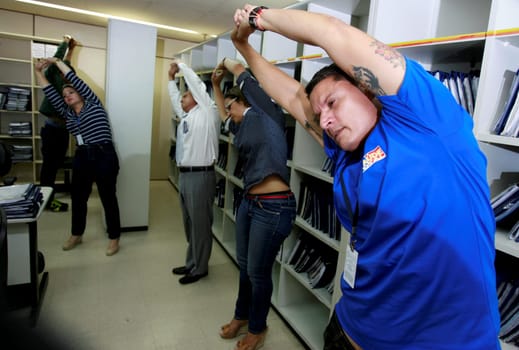 salvador, bahia / brazil - december 17, 2014: employees of the regional labor court in the city of Salvador are seen doing work gymnastics in the workplace.