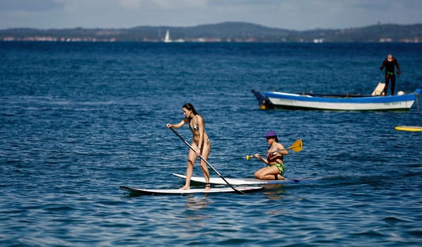 salvador, bahia / brazil - october 25, 2014: people are seen practicing Stand Up on Porto da Barra beach in the city of Salvador.