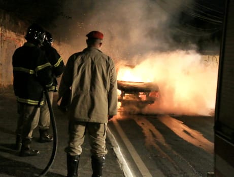 salvador, bahia / brazil - october 29, 2015: members of the fire brigade put out a fire in a vehicle in the city of salvador.