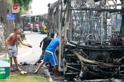 salvador, bahia / brazil - december 25, 2014: people collect a piece of bus from the burnt transport in the city of Salvador.