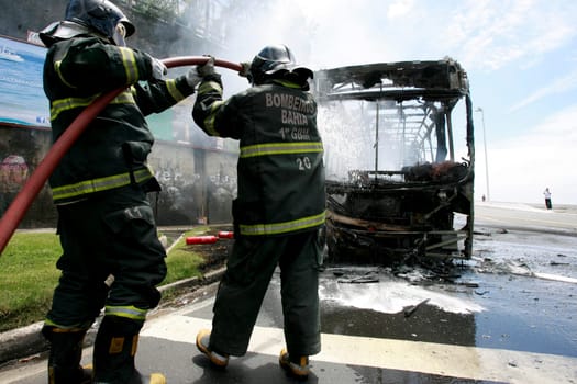 salvador, bahia / brazil - december 25, 2014: members of the fire brigade extinguish a fire on a public transport bus in the city of salvador.